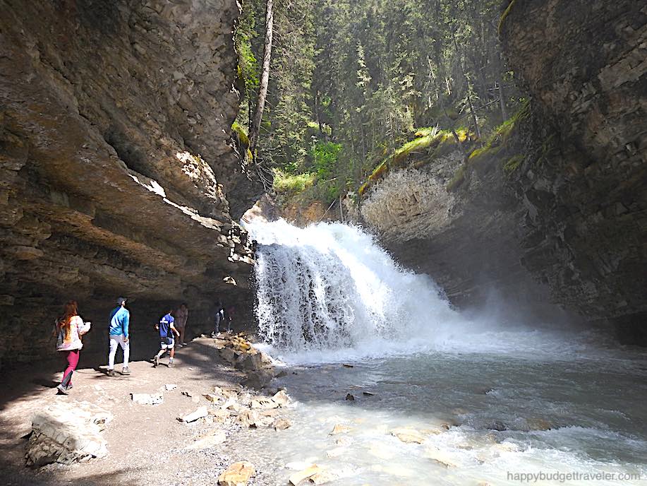 Picture of people walking towards the back of the Cavern to go behind the Falls. Johnston Canyon, Banff-Canada
